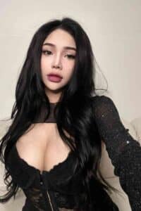 Portrait of a woman with long black hair, wearing a black lace top.